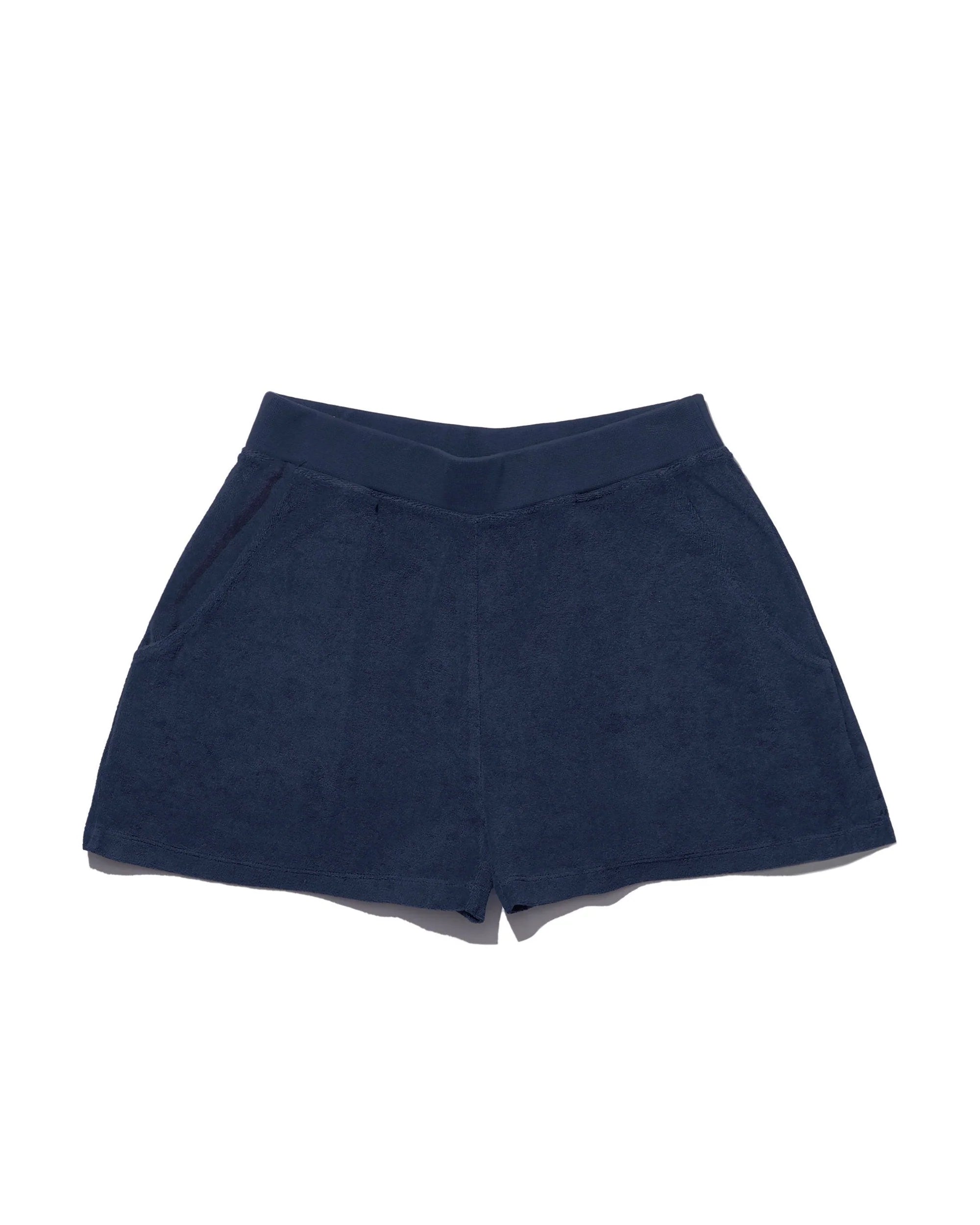 The Terry Venus short by Kule, in navy blue cotton-blend terry, features an elastic waist and side pockets, shown laid flat on a white background.