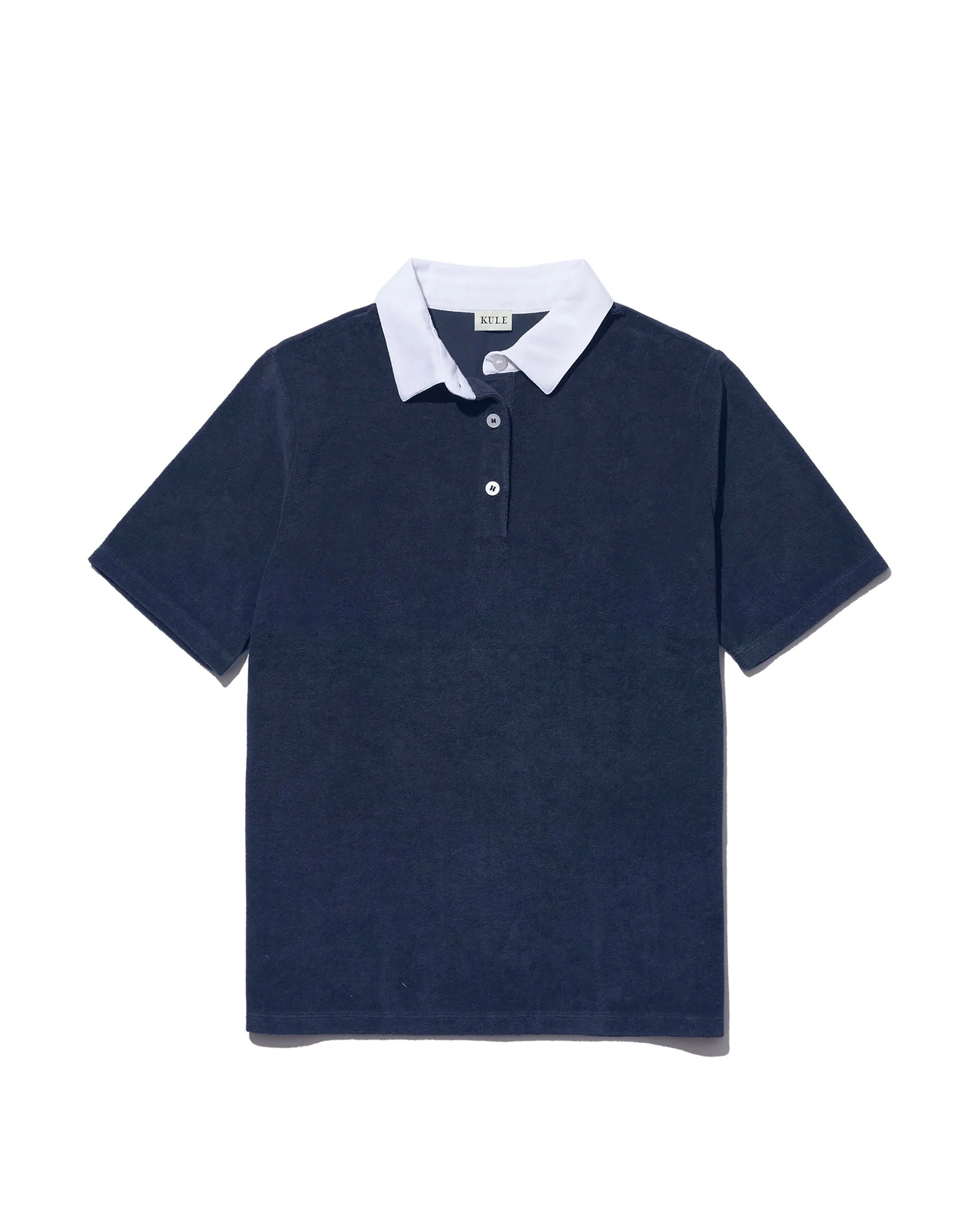 The Kule Terry Polo is a sporty, chic short-sleeve navy blue cotton terry shirt with a white collar and two-button placket, displayed flat on a white background.
