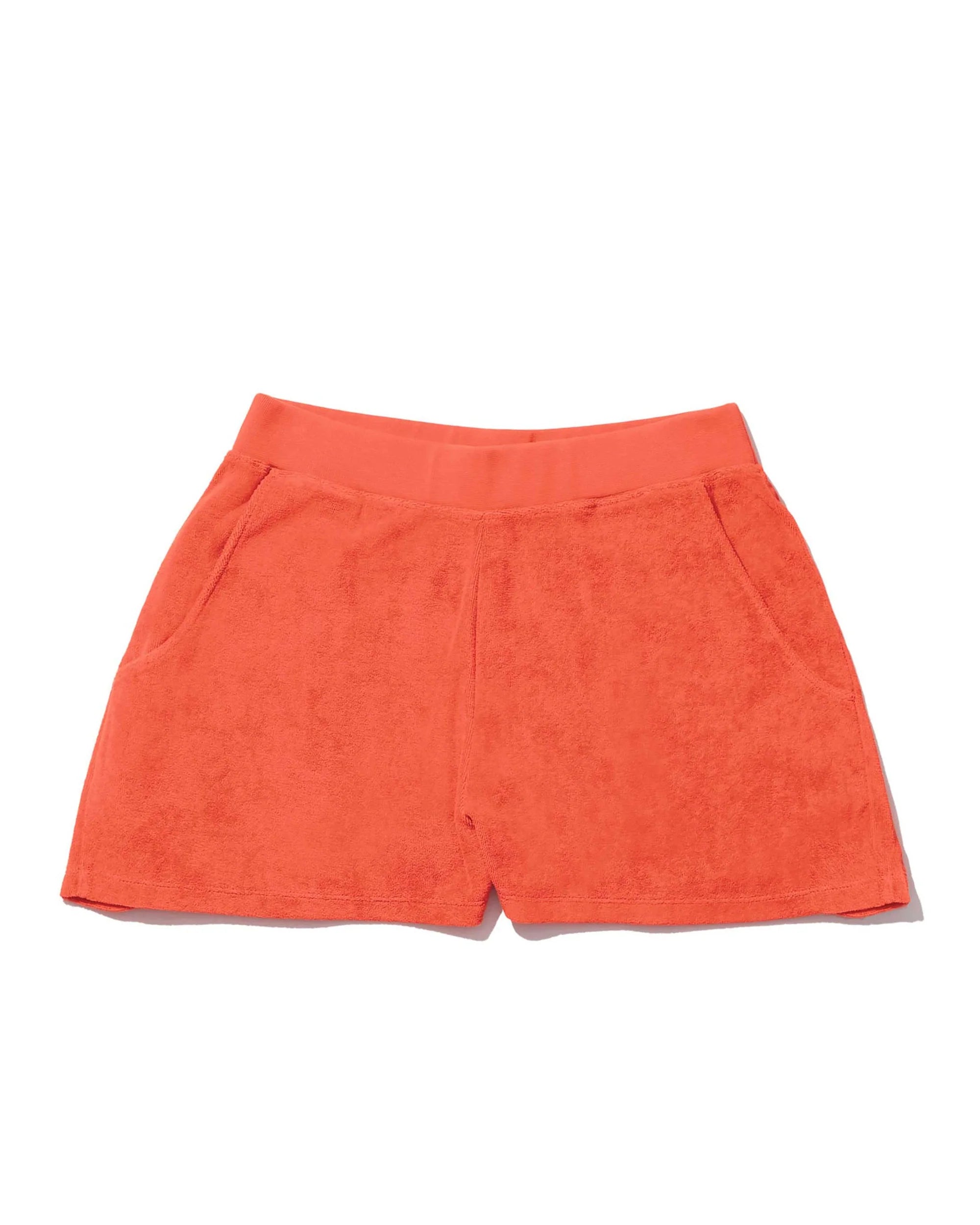 The Terry Venus short by Kule, in bright orange cotton-blend terry, features an elastic waist and front pockets. Shown laid flat on a white background.