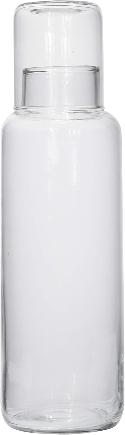 The Creative Co-op Decanter With Glass is a clear, empty glass bottle with a matching lid—ideal as picnic drinkware or elegant tableware—pictured against a plain white background.