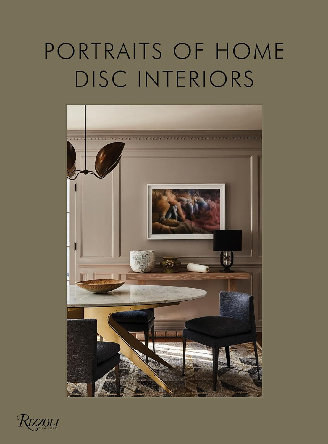 The cover of "Portraits Of Home" by Random House features modern elegance with a chic dining room, showcasing a round marble table, dark chairs, and a contemporary chandelier. Eye-catching artwork and a soothing beige palette demonstrate DISC Interiors' refined style.