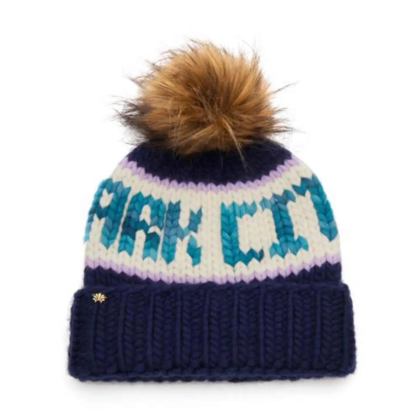 The Faire Knit Ski Hat is a luxury navy blue beanie with a brown faux fur pom pom, bold white and teal "PARK CITY" lettering, a folded cuff, and a small metallic emblem for extra style.