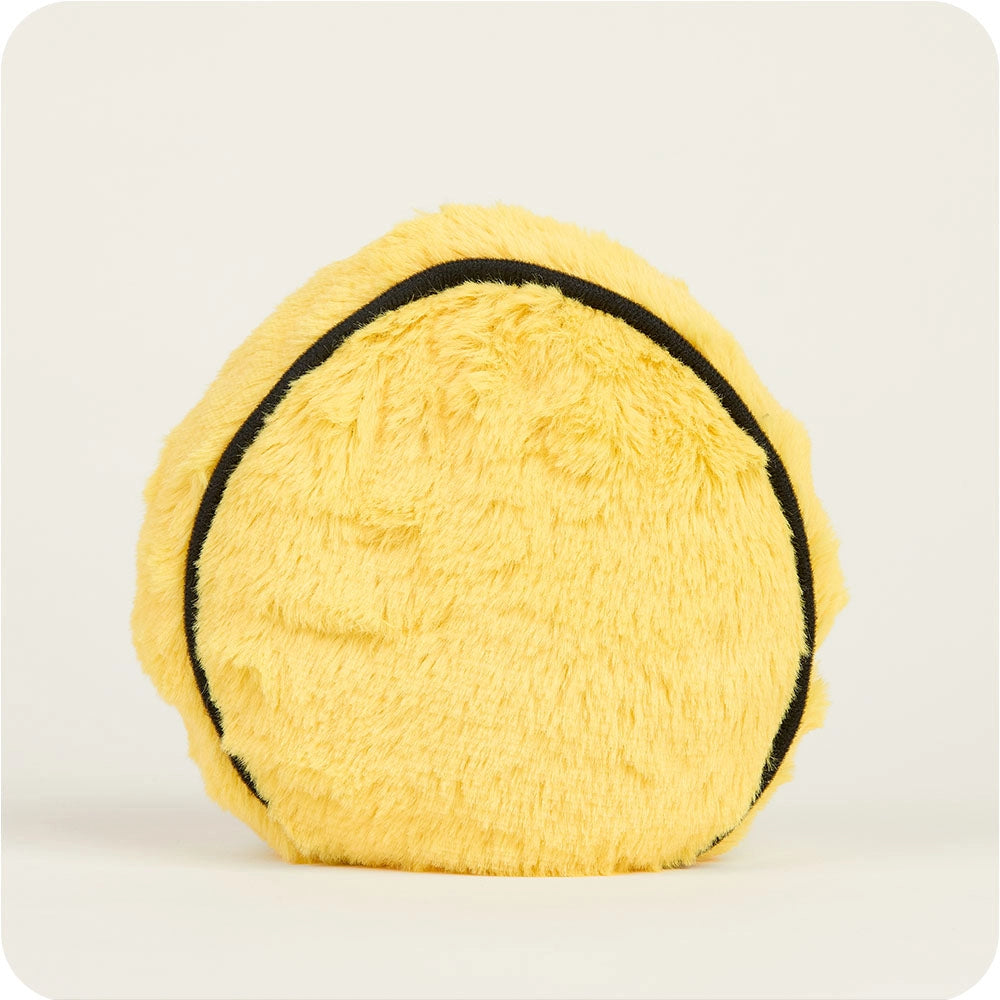 The Faire Smiley Face Warmies Junior is a round, yellow plush with a black outline, photographed on a white background. This microwavable soft toy offers sensory comfort and works as both a cushion and cuddly companion.
