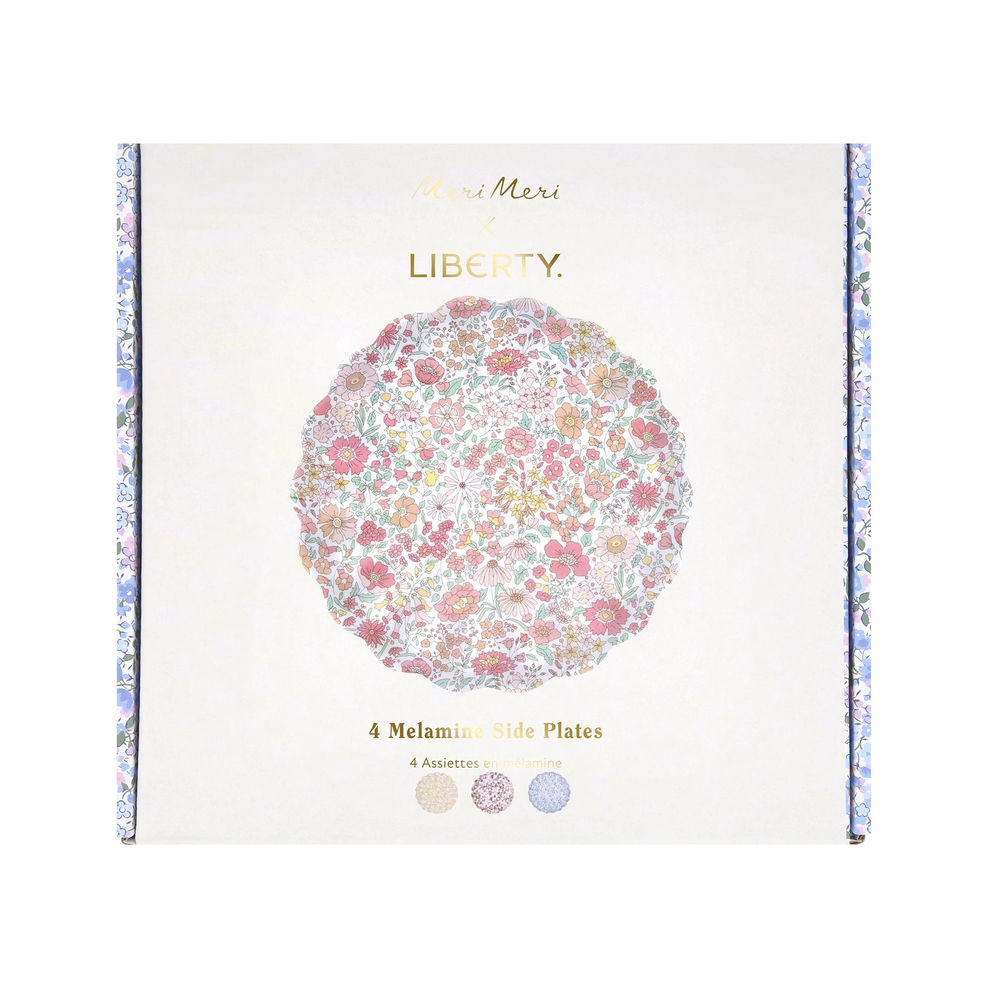 Box of Faire Mixed Set Reusable Small Plates, visible through a packaging cutout. The pastel floral pattern and scallop-shaped plates add charm, with the white box featuring gold text and floral side details.