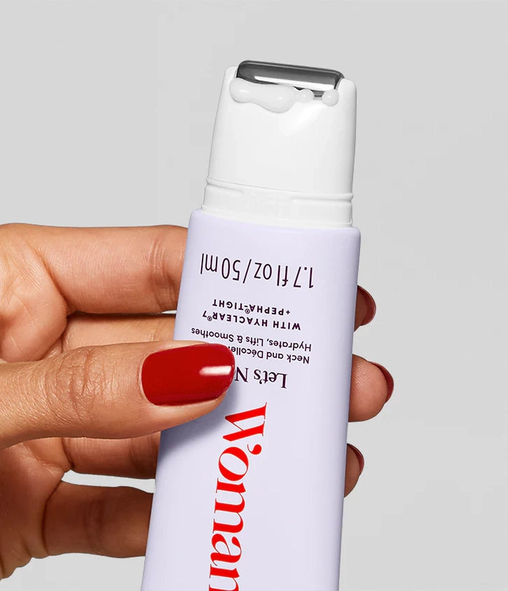 A hand with red nail polish holds Faire's Let's Neck - Neck Serum w/ Cooling Applicator, topped with white lotion. The light-colored bottle features measurement markings and partial text in red and black.