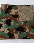 The Faire Cheyenne Camo Quilt features a green, brown, black, and tan camouflage pattern with a beige floral underside. Modern quilt fans will love this design from Fort Worth, Texas.
