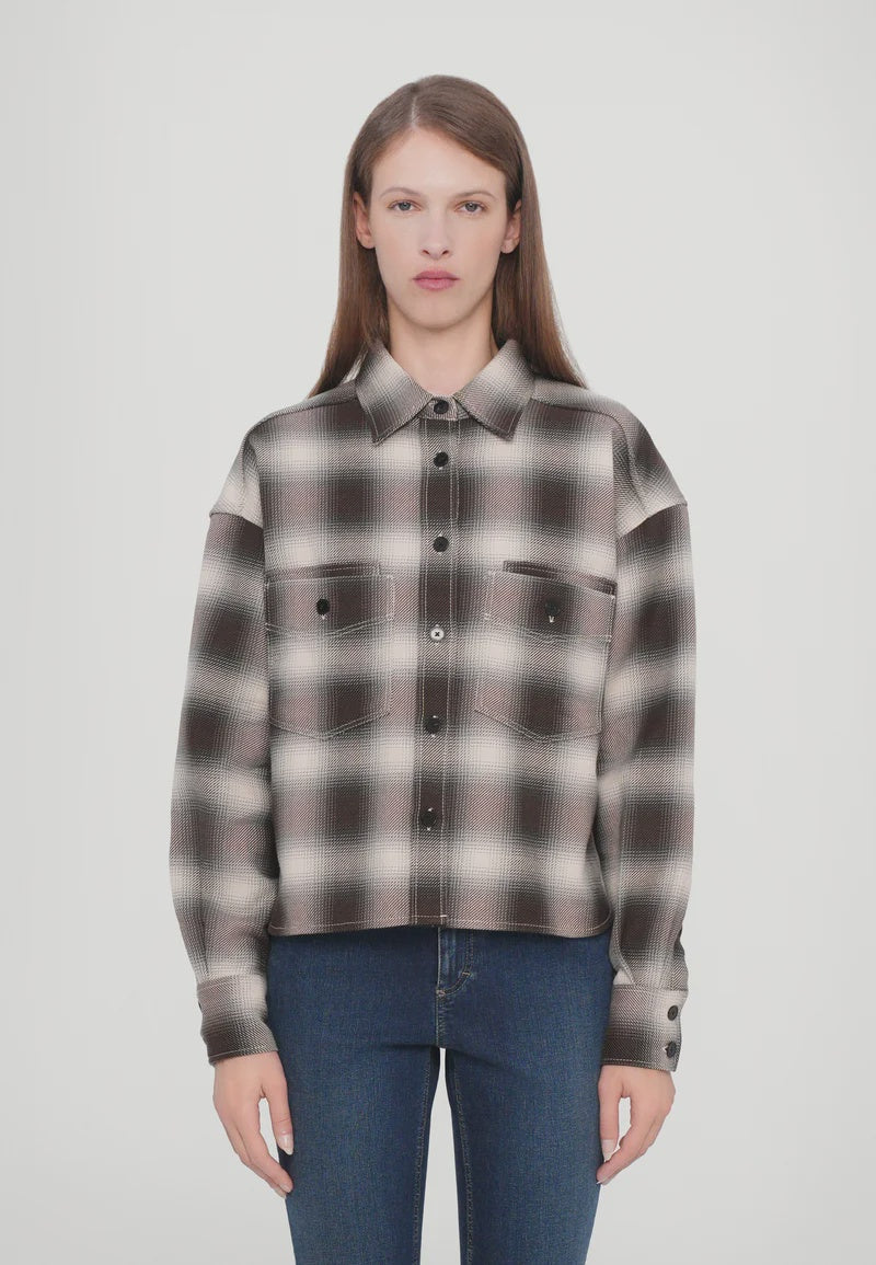 A person with straight, long brown hair is wearing the CLOSED Cropped Front OS Shirt in a black, white, and grey checkered print with chest pockets and blue jeans, standing against a plain white background.
