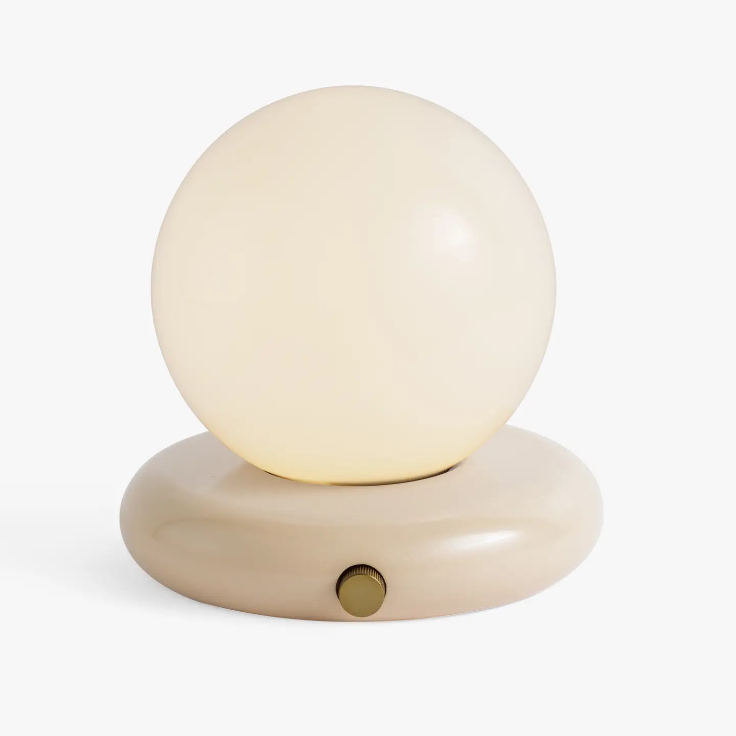 The Valencia Portable Light by Faire is a minimalist lamp with a round, frosted glass globe on a smooth, oval beige base and a small brass knob on the front.