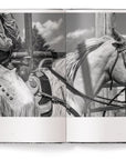 A black-and-white photo from "A Ranch Year" by Ingram Book Company captures a cowboy on horseback in fringed chaps, embodying Wyoming ranch life—an evocative piece of American West photography.