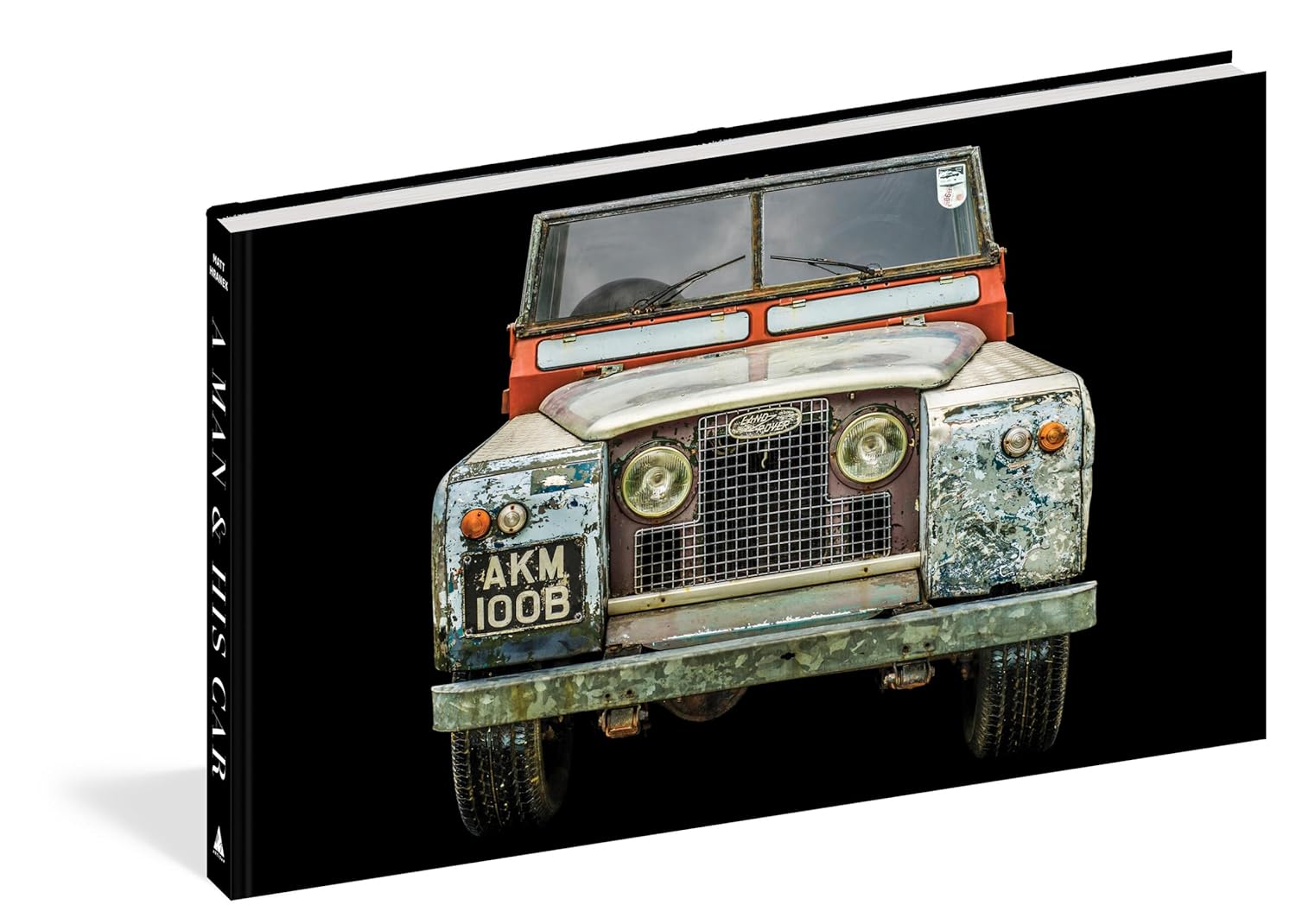 A perfect coffee table book for car lovers, "A Man & His Car" by Hachette Book Group features a striking cover image of a vintage Land Rover with its "AKM 100B" plate set against a black background.