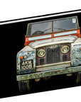 A perfect coffee table book for car lovers, "A Man & His Car" by Hachette Book Group features a striking cover image of a vintage Land Rover with its "AKM 100B" plate set against a black background.