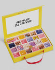 The yellow box with a red handle, titled "Make It Super DIY Bead Kit" by Faire, is filled with colorful beads and accessories neatly organized in compartments. The lid features the brand "SUPER SMALLS" printed in black.