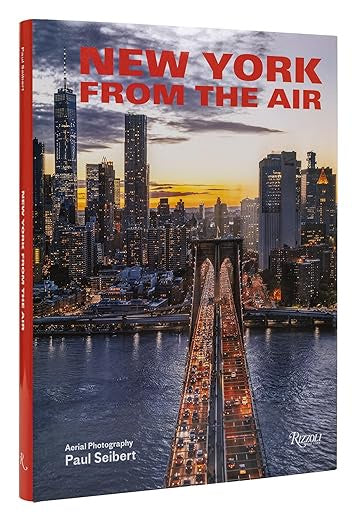 The cover of &quot;New York from the Air,&quot; published by Random House, showcases breathtaking aerial views of New York City at dusk, featuring the Brooklyn Bridge and shining skyscrapers set against a vibrant sky—an ideal capture for photography enthusiasts.