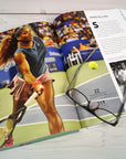 Tennis The Ultimate Book by Random House lies open, featuring a vivid forehand photo and historic black-and-white images—eyeglasses atop—making it an ideal coffee table piece for tennis enthusiasts and history lovers.