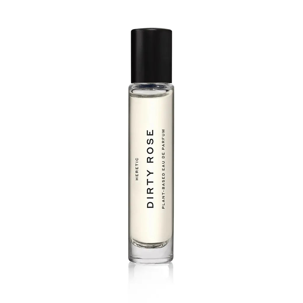 A clear glass bottle of Faire Heretic 15ML Perfume, featuring Damascena rose and sandalwood vanilla notes, stands upright with a black cap on a white background.
