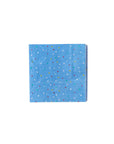 The MME Napkin by Faire features a pattern of small, colorful dots evenly spread across its blue surface. It is neatly folded into a square and placed against a white background.