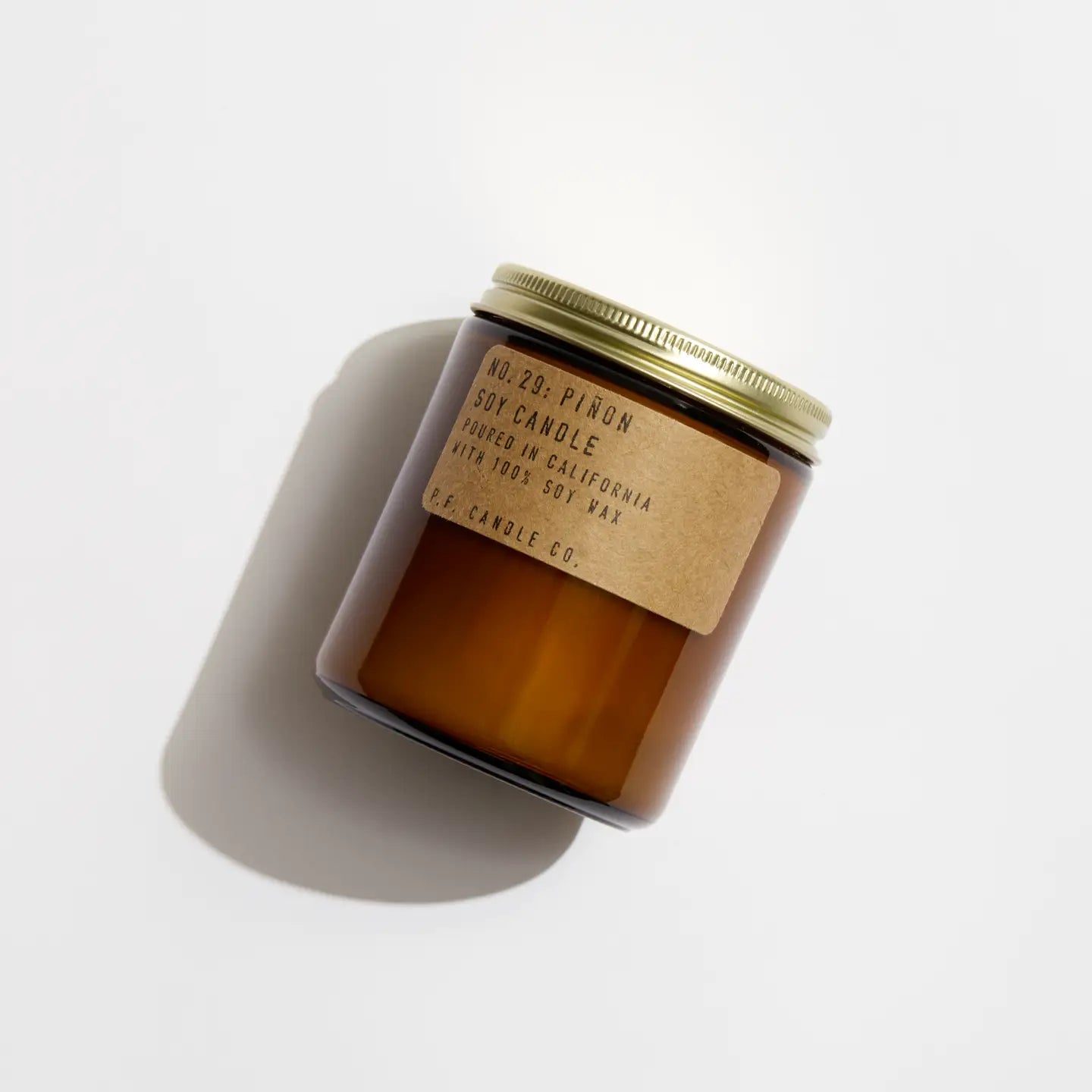 This hand-poured PFC Candle by Faire comes in a brown glass jar with a gold lid and features No. 21: Piñon scent, made from 100% soy wax and fine fragrance oils for a clean, inviting burn.