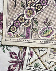 Close-up of vintage-style domino paper from "A Year in the French Style" by Random House, featuring pink, green, and yellow floral patterns and overlapping sheets that reflect classic French design.