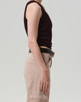 A person stands in profile against a plain background, wearing the Isabel Rib Tank F25 by Citizens Of Humanity/AGOLDE, paired with beige cargo pants featuring visible pockets and accessorized with a gold chain necklace.