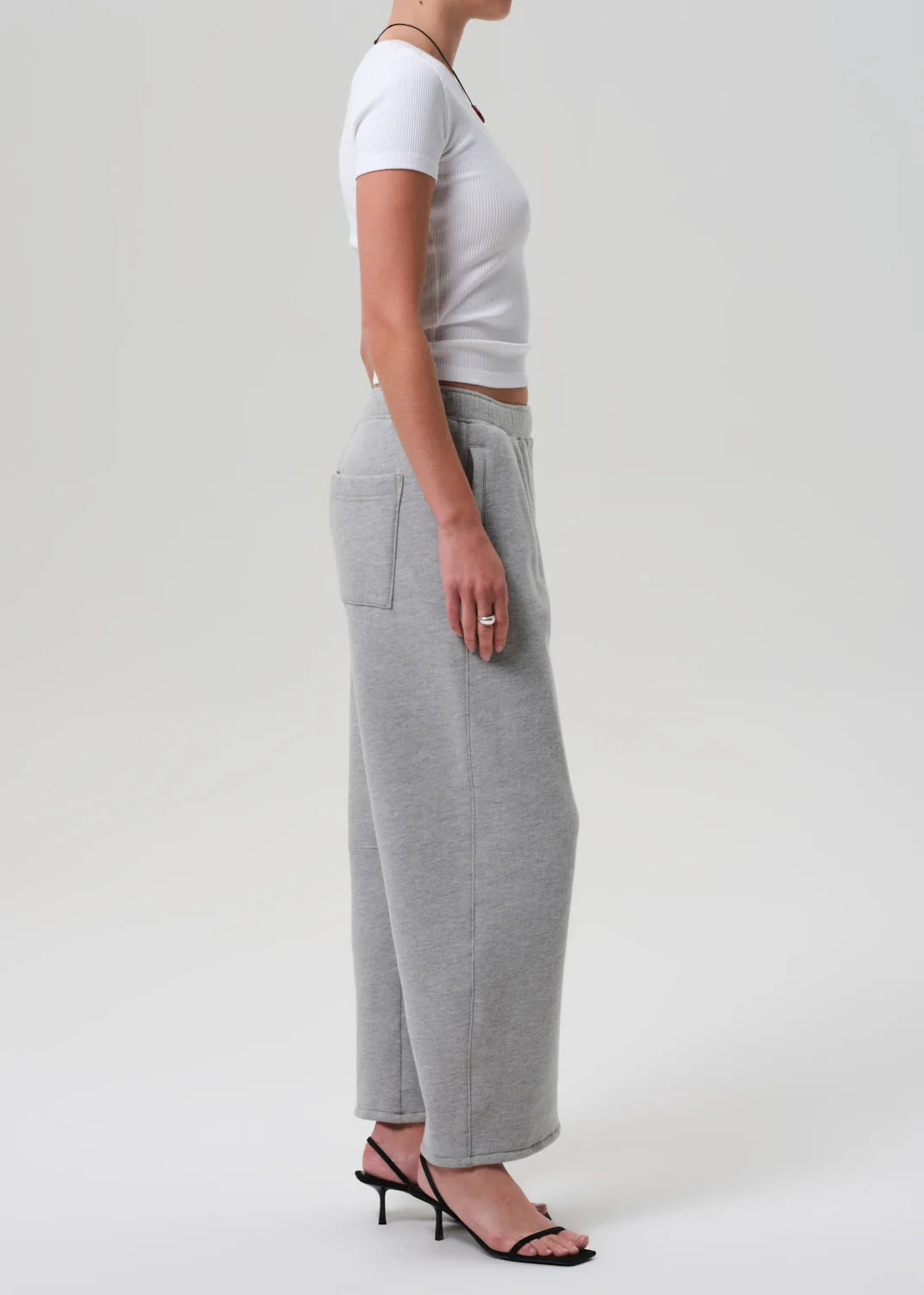 Heather grey Miro Sweatpant by Citizens Of Humanity/AGOLDE styled with a white crop top and black heels.