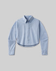 The ana cropped shirt in banker blue plaid by Citizens Of Humanity/AGOLDE features a light blue and white check pattern, button-up front, long sleeves, and pointed collar. Shown against a plain gray background.