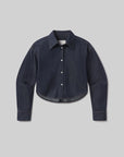 The Ana Cropped Shirt in Piave by Citizens Of Humanity/AGOLDE features a dark indigo hue, long sleeves, a collar, and button-down front, crafted from premium Japanese denim and shown on a light gray background.