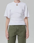 Model wearing the fabien tee by Citizens Of Humanity/AGOLDE, paired with olive green pants and a gold pendant necklace, shot from shoulders to hips against a plain light gray background.
