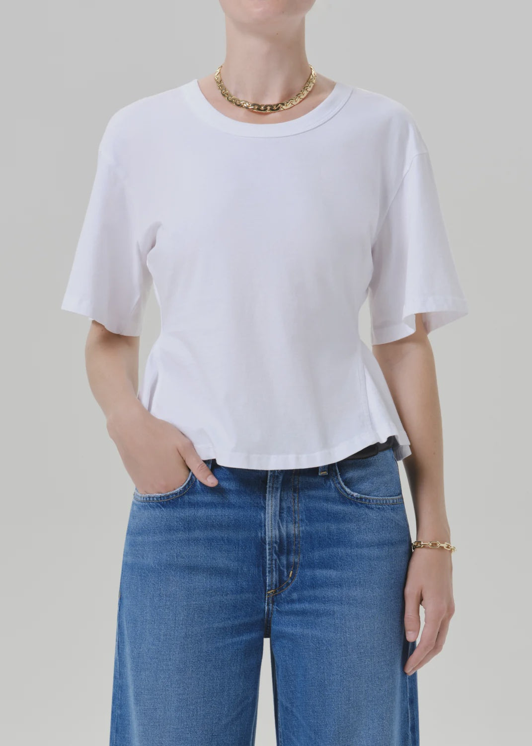 Citizens Of Humanity rework mens tee in white, paired with blue jeans and gold accessories, casual modern style.