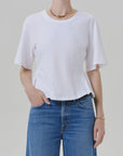 Citizens Of Humanity rework mens tee in white, paired with blue jeans and gold accessories, casual modern style.