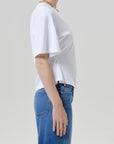 Rework mens tee by Citizens Of Humanity/AGOLDE in white, paired with blue jeans, casual look against light grey backdrop.
