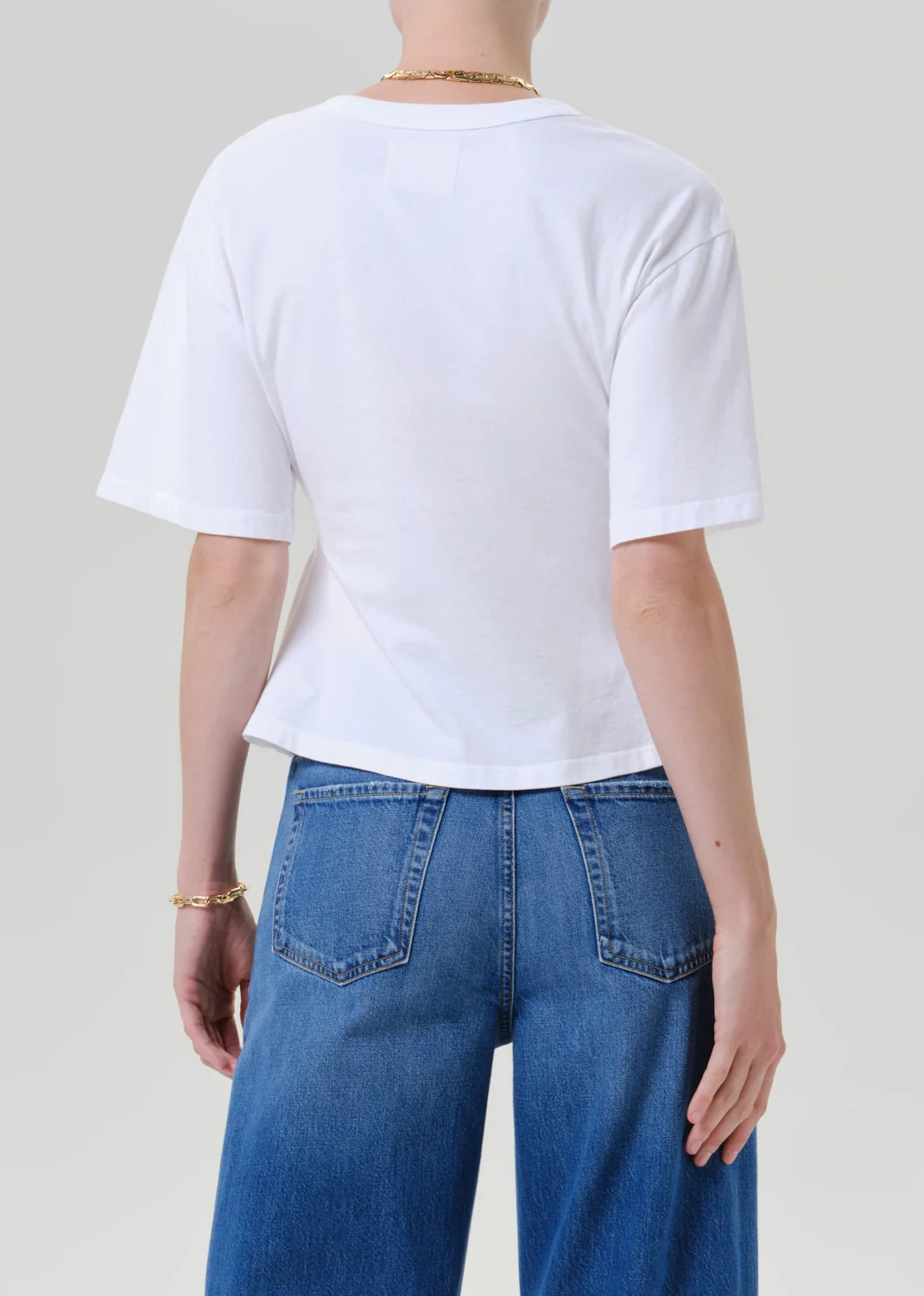 Rework mens tee by Citizens Of Humanity/AGOLDE in black, back view, styled with blue jeans on gray background.