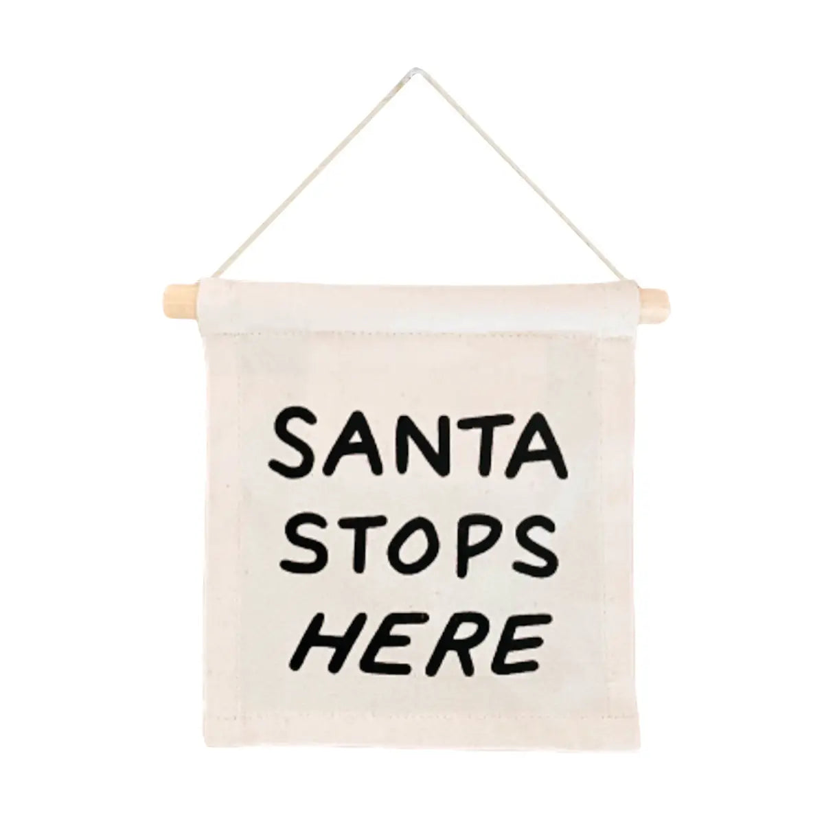 A Canvas Hang Sign by Faire, featuring a small beige design made from natural canvas, is suspended from a wooden dowel with "SANTA STOPS HERE" boldly screen printed in black letters.