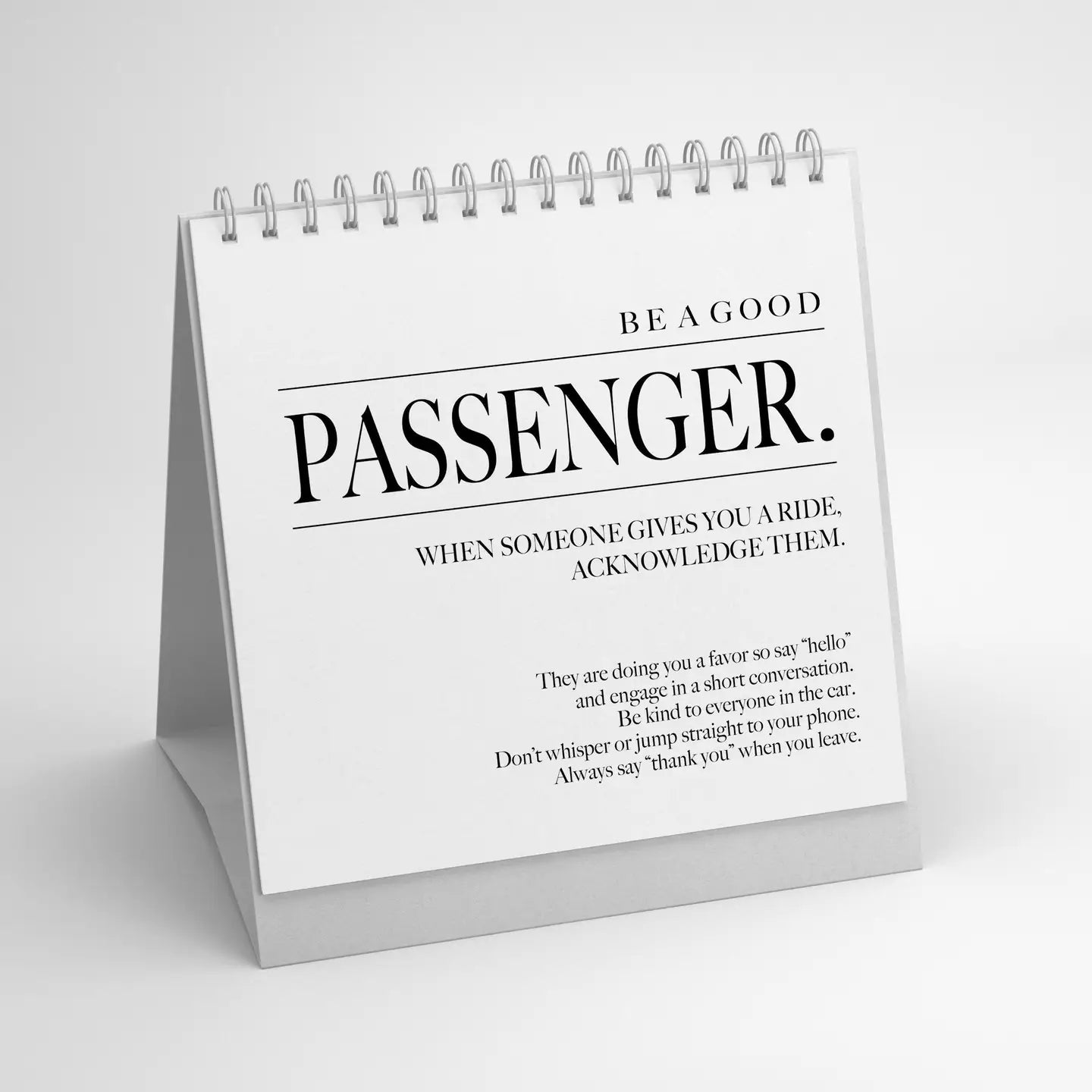 The Faire 52 Modern Manners white flip calendar, inspired by classic flip books, reminds: "Be a good passenger. When someone gives you a ride, acknowledge them," plus etiquette tips—be polite, engage in conversation, and thank the driver.