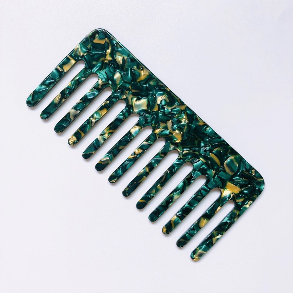 The Faire Hair Comb Assorted, featuring a wide-tooth anti-static design and a green-yellow marbled pattern, is displayed on a white background.