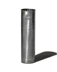 The Faire Steel Trashcan, tall and cylindrical with a smooth, reflective surface, stands upright on a white background and casts a distinct shadow to the right.