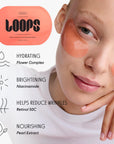 A woman wears two translucent peach eye masks under her eyes, using the Faire LOOPS HydroGel Eye Masks. Beside her is the set with text highlighting benefits: hydrating, brightening, dark circle reduction, and nourishing.