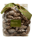 A clear plastic bag of Potpourri from Faire, filled with pine cones and tied with a green ribbon and twine. The label reads "fresh cut balsam & pine"—the perfect Christmas scent to pair with holiday candles.