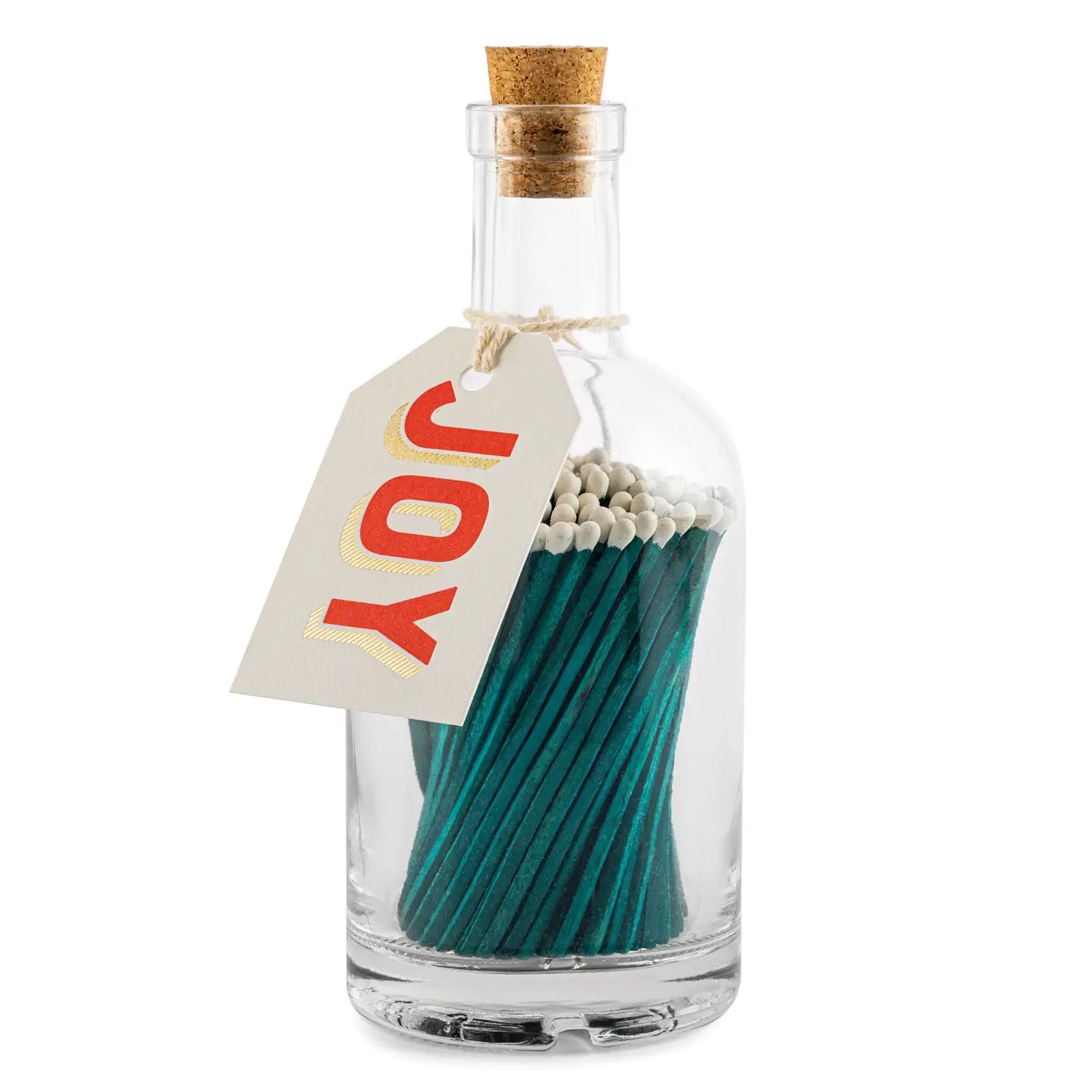 Faire's Glass Bottle Matches, from our sustainable home collection, feature green-tipped matches in a cork-stopped bottle. A "Joy" tag in red and gold hangs on twine at the neck, highlighting the eco-friendly, plastic-free packaging.