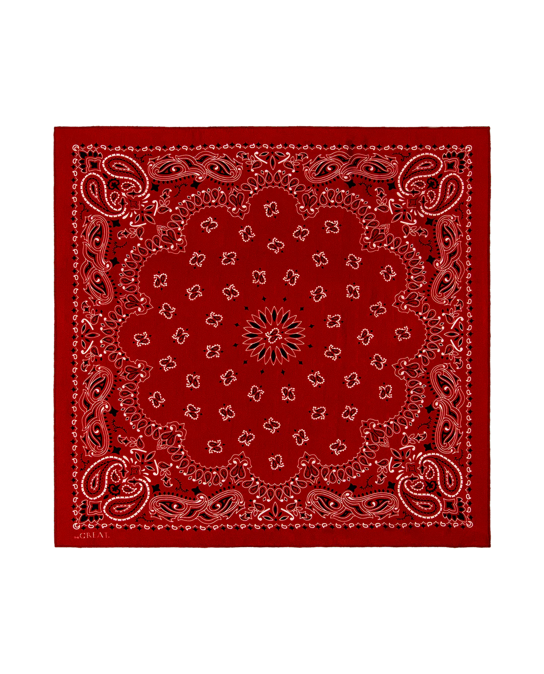 The Great Inc. presents The Silk Bandana—a red silk accessory with a classic paisley pattern and detailed white and black designs on the border and center, shown against a plain white background.