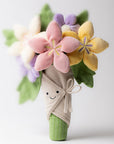 Jelly Cat Inc.’s Bouquet of Flowers features soft pastel blooms in pink, yellow, and purple with green leaves, wrapped in beige fabric with a bow. The plush bouquet has a smiling face, making it an adorable and playful gift.