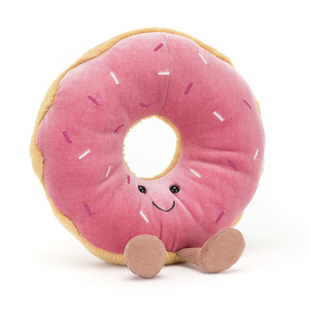 Introducing the Jelly Cat Inc. Amuseables Doughnut, a plush donut toy with berry-pink icing, rainbow sprinkles, a smiling face, and small brown legs.