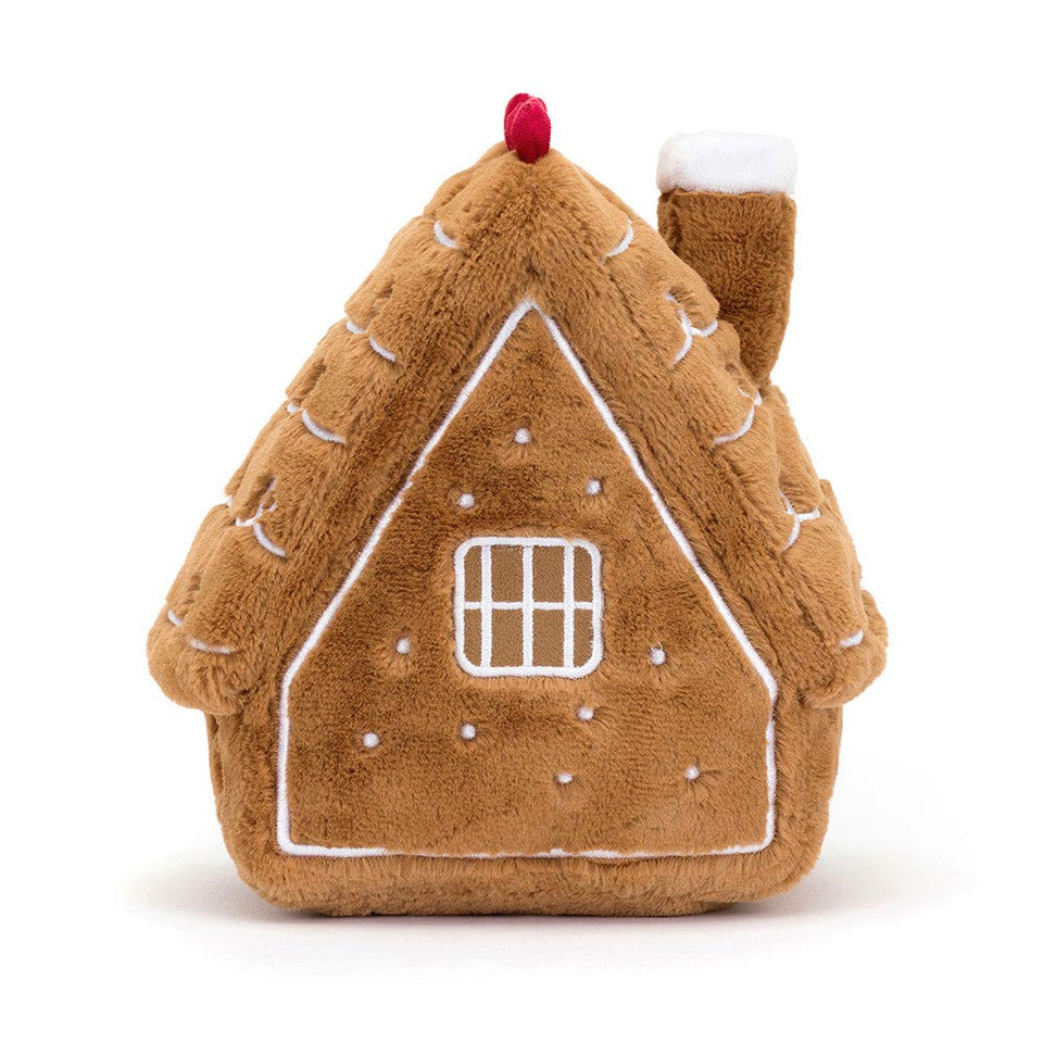 The Amuseables Gingerbread House by Jelly Cat Inc. is a plush toy featuring white icing, a square window, a red dot on top, and a soft chimney on the right side.