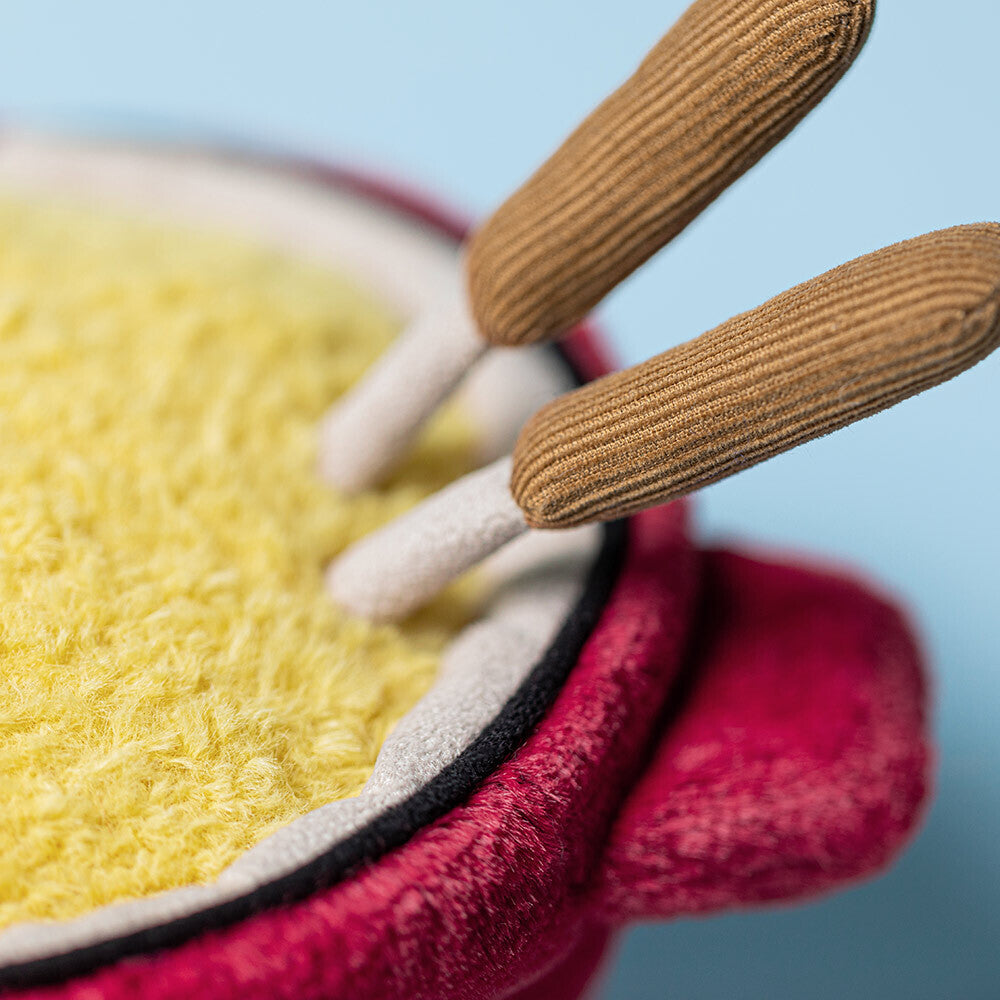 Close-up of the Amuseables Cheese Fondue by Jelly Cat Inc.—a plush toy shaped like a red fondue pot with a fuzzy yellow interior and brown handles, perfect for Switzerland fans or cozy dinner party décor.