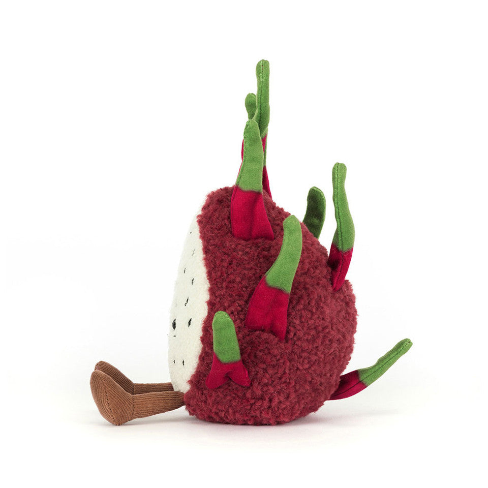 A Jelly Cat Inc. Dragon Fruit plush toy, featuring an exotic design with green fabric leaves and a white center dotted with black, is shown lying on its side against a white background.