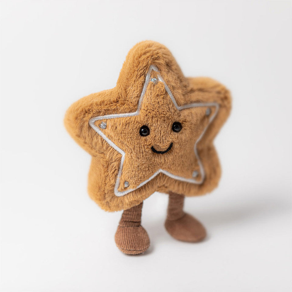 The Jelly Cat Inc. Amuseables Star Cookie is a plush toy shaped like a brown star cookie, featuring embroidered details, black eyes, a stitched smile, and soft brown legs, pictured standing on a white background.