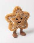 The Jelly Cat Inc. Amuseables Star Cookie is a plush toy shaped like a brown star cookie, featuring embroidered details, black eyes, a stitched smile, and soft brown legs, pictured standing on a white background.