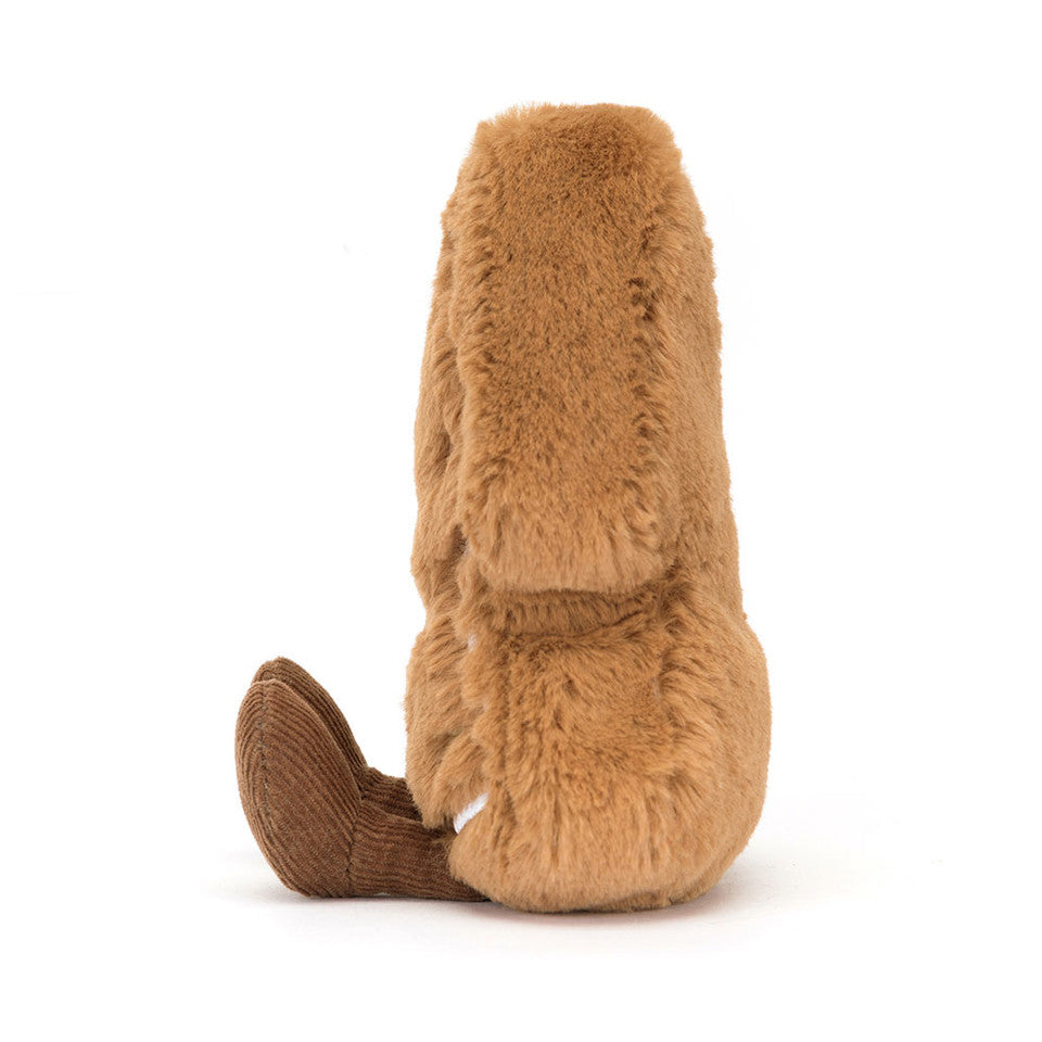 A plush bunny with light brown, fluffy fur and a corduroy-textured foot sits upright, facing away—an ideal companion for gift-wrapping pros to pair with Jelly Cat Inc.’s Amuseables Tree Cookie.