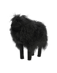 The Faire Tibetan Lamb Sheep features dense, curly black fur resembling genuine Tibetan Lamb wool. This minimalist plush stands on four legs without visible facial features, making it a chic and soft addition to a nursery against a plain white background.