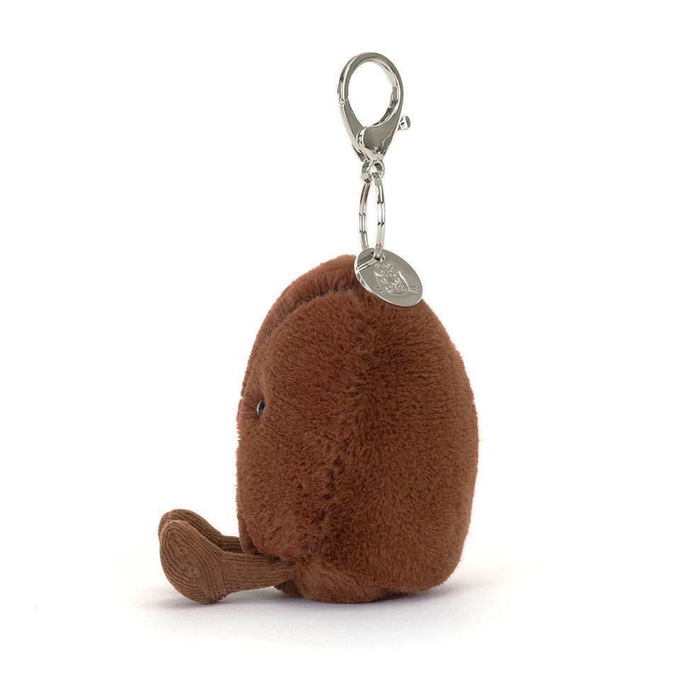A small, brown, plush kiwi bird keychain with a metal clip and tag on top. Its cute round body and fuzzy texture make it an adorable accessory—great to pair with your Jelly Cat Inc. Amuseables Coffee Bean Bag Charm.