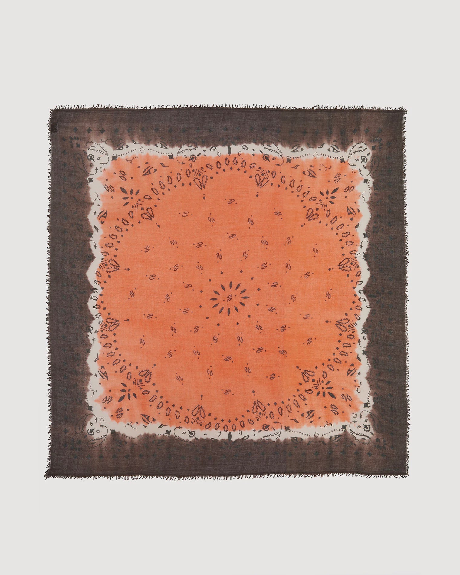 The Effy Square Scarf by KUJTEN is an extra large orange and black paisley scarf with small floral motifs and frayed edges, shown flat on a white background.